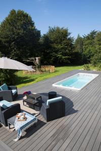 een terras met een zwembad en stoelen en een tafel bij EDEN Locquirec - Piscine & Spa Chambre d hôtes in Locquirec