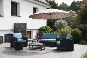 een patio met blauwe stoelen en een parasol bij EDEN Locquirec - Piscine & Spa Chambre d hôtes in Locquirec