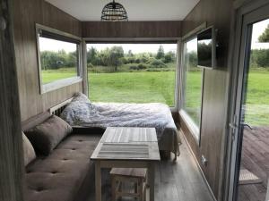 uma cama e um sofá num quarto com uma janela em SKY Ranch em Izborsk