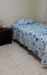 卡利的住宿－Habitaciòn Cambulos 3，一间卧室配有一张带波卡圆点床单的床