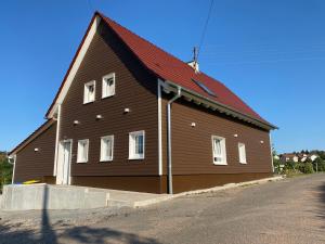 un grand bâtiment marron avec un toit rouge dans l'établissement Grimm´s Landhaus, à Mudau