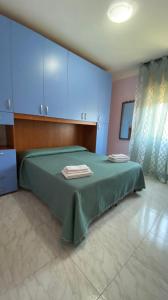 Un dormitorio con una cama verde con toallas. en Appartamento da Lena, en Policastro Bussentino
