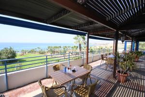 un patio avec une table et des chaises et l'océan dans l'établissement Helios 2, à Paphos