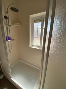 a shower in a bathroom with a window at Apartamento Vicentino in Vila Nova de Milfontes