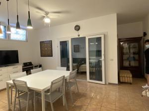 une salle à manger avec une table et des chaises blanches dans l'établissement casa turro, à Milan