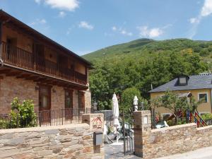 un edificio con balcón y una montaña en el fondo en Las Fontaninas, en Noceda del Bierzo