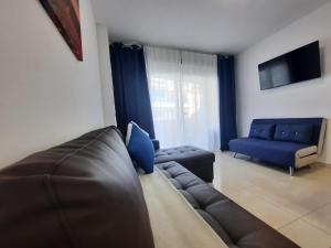 Una sala de estar con un sofá de cuero y un sofá azul. en Cristina, en Calpe