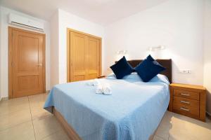 Un dormitorio con una cama azul con toallas. en Cristina, en Calpe