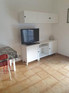 Zimmer mit einem weißen Schreibtisch und einem TV. in der Unterkunft Studio 88 - free Parking in Lloret de Mar