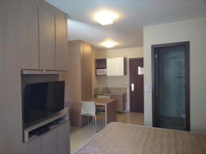 un salon avec une télévision et une table avec des chaises dans l'établissement The Sun Full Condominiun, à Brasilia