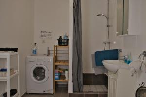 a bathroom with a washing machine and a sink at The Coffee House in Selfoss