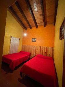 2 posti letto in una camera con lenzuola rosse di Cabaña en Mazamitla - Jade a Mazamitla
