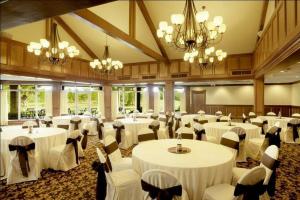 a banquet hall with white tables and chairs and chandeliers at Hollywood Casino Gulf Coast in Bay Saint Louis