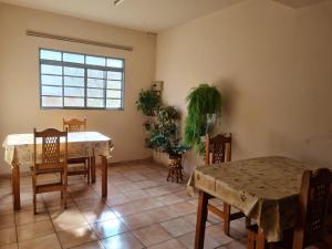 a dining room with tables and chairs and a window at Hotel Glória in Londrina
