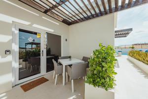 een eetkamer met een tafel en stoelen op een balkon bij Lux Villa's by GG in Palm-Eagle Beach