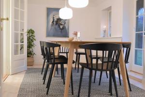 comedor con mesa de madera y sillas negras en Tanggården Skoven en Læsø