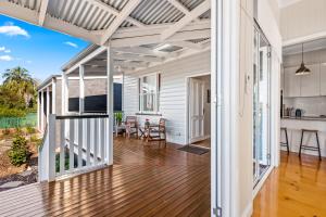 un soggiorno a pianta aperta con pavimento in legno e pareti bianche. di Bluestone Cottages - The Shop a Toowoomba