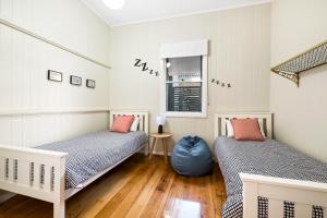 una camera da letto con due letti e una finestra di Bluestone Cottages - The Shop a Toowoomba