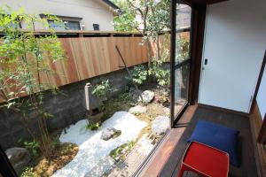 a garden outside a house with a sliding glass door at Hashibaya TABI-NE in Kanazawa +8 photos