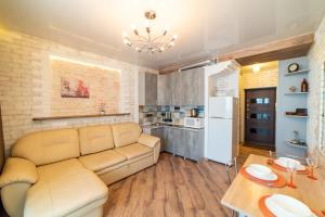 una sala de estar con un sofá y una mesa en Дизайнерская студия на Броско, en Khabarovsk 17 fotos más
