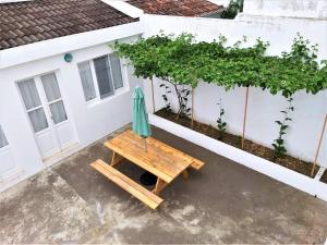 a picnic table with an umbrella in front of a house at Adamas Bed & Breakfast in Ponta Delgada