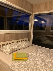 um quarto com uma cama com uma janela e uma toalha verde em SKY Ranch em Izborsk