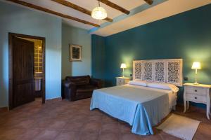 卡斯特里爾的住宿－綠色壁虎酒店，一间卧室配有一张床、一张沙发和一把椅子
