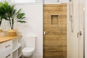 a bathroom with a toilet and a glass shower door at Bluestone Cottages - The Villa in Toowoomba