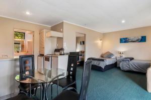 une chambre avec une cuisine et un salon avec une table dans l'établissement Motuoapa Studio - Motuoapa Holiday Unit, à Turangi