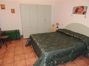 a bedroom with a bed with a green bedspread at Agriturismo Podere Borgognano in Massa Marittima