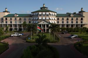 een groot gebouw met auto's geparkeerd op een parkeerplaats bij Royal Torarica in Paramaribo