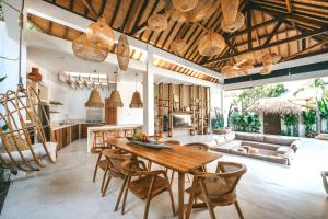 烏魯瓦圖的住宿－MODJO Villas Bingin，厨房以及带木桌和椅子的客厅。