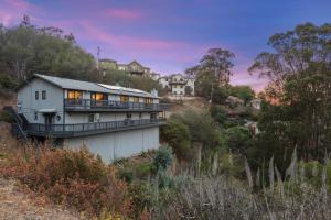 una casa al lado de una colina con árboles en @Marbella Lane - 3BR Penthouse Executive Suite, SFO, Parking en Brisbane