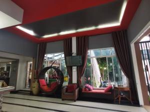 sala de estar con sofá y espejo en Grand Pruksa Siri Apartment, en Saraburi