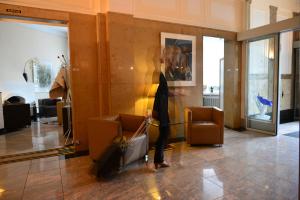 a person is standing in a lobby with luggage at Frühlings-Hotel in Braunschweig