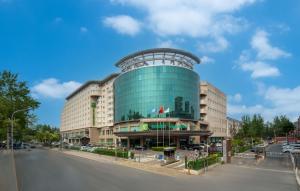 a large building with a glass facade on a street at Holiday Inn Beijing Chang An West, an IHG Hotel in Beijing