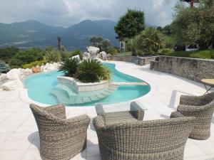 a swimming pool with chairs and a fountain at Villa Romele in Pisogne