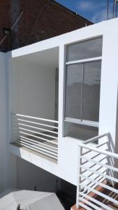 a white house with a window and a staircase at Departamento Mapy en Piura in Piura