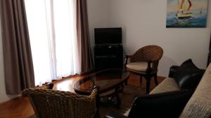 a living room with a couch and a table and chairs at Lazar Apartments in Petrovac na Moru