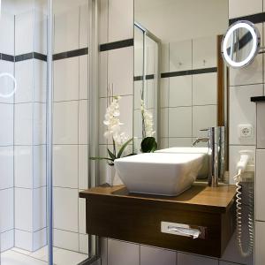 Boutique-Hotel Moseltor & Altstadt-Suiten في ترابن ترارباخ: حمام مع حوض ومرآة