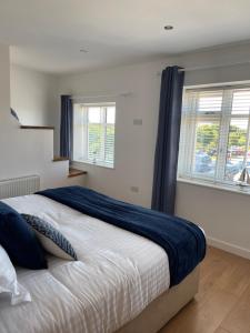 a bedroom with a large bed with two windows at The Hideout in Anderby