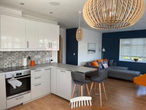 a kitchen with white cabinets and a living room at The Hideout in Anderby