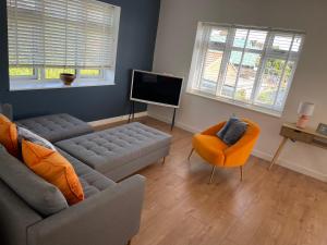 a living room with a couch and a flat screen tv at The Hideout in Anderby