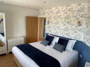 a bedroom with a blue and white bed with pillows at The Hideout in Anderby