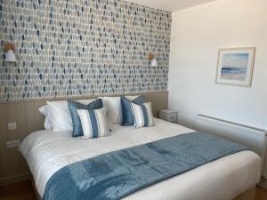 a bedroom with a bed with blue and white pillows at The Hideout in Anderby