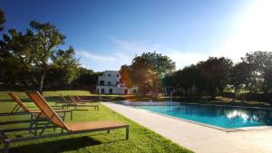 a pool with lounge chairs next to a house at Tenuta Monacelle in Selva di Fasano