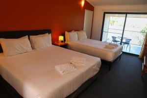 um quarto de hotel com duas camas e uma varanda em De Lago Resort On Lake Bennett em Lake Bennett