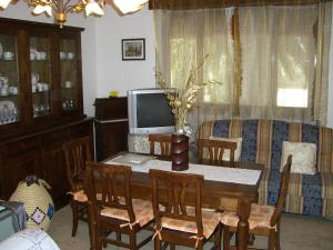 a living room with a dining room table with a television at Sa Domu Sarda casa vacanza in Piscinas