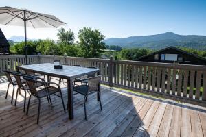 a table and chairs on a deck with an umbrella at Ferienhaus Megumi in Siegsdorf