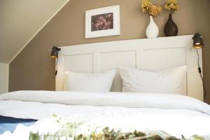 1 Schlafzimmer mit 2 Betten und weißen Kissen in der Unterkunft Urlaubsfreude Biedermann Haus Blumenglück - Hortensie in Sebnitz